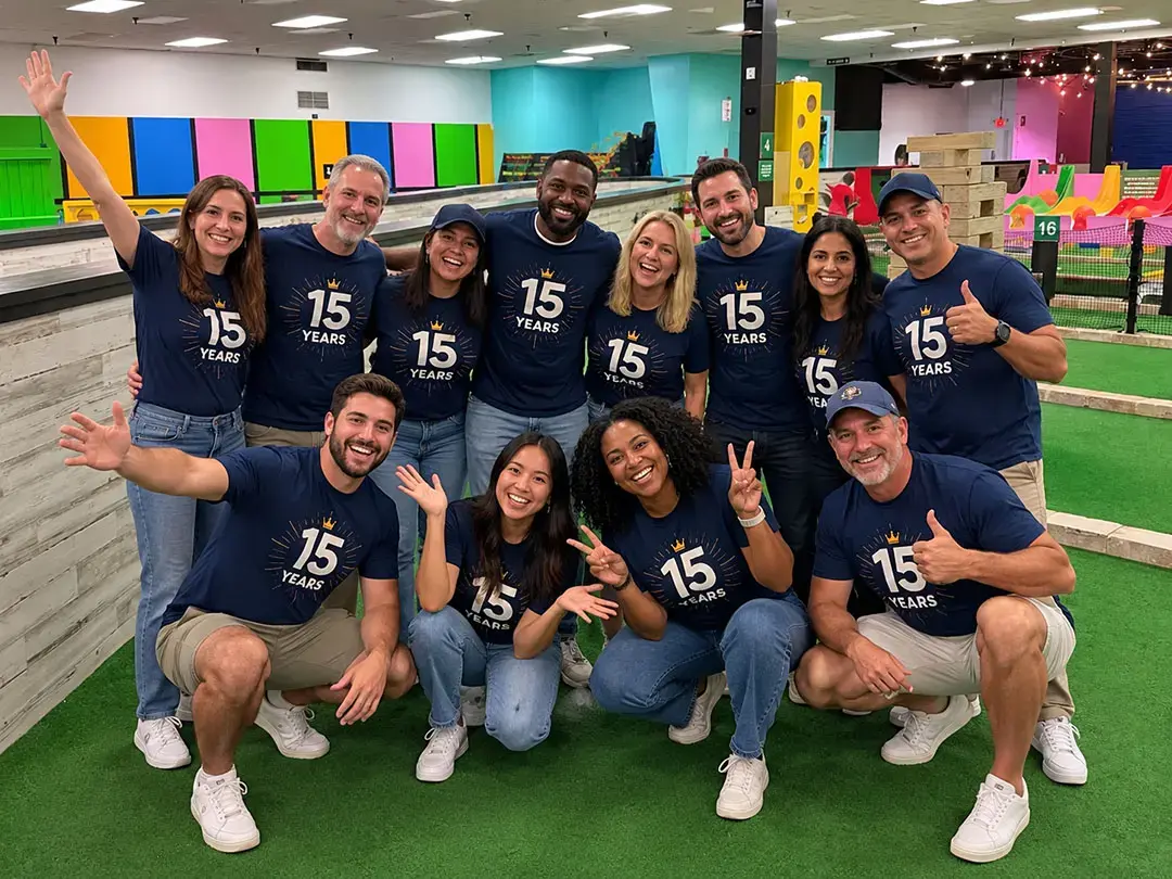 Group in matching 15 Years shirts poses on an indoor mini golf course at Mr. Putters in Tampa, FL